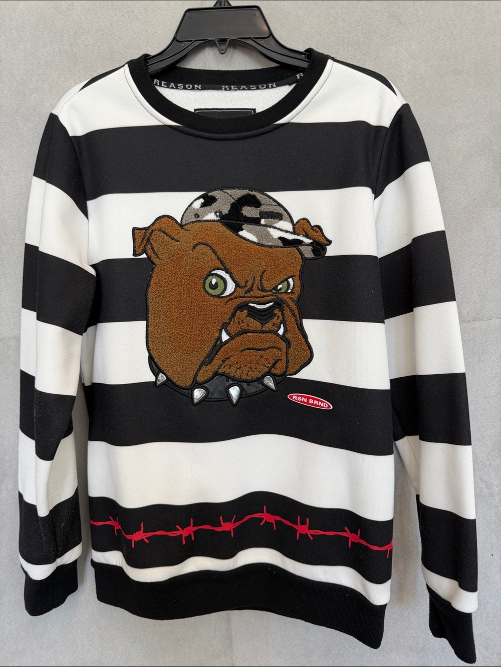 Reason Black & White Striped Bulldog Sweater with Brown Patch and Red Accent.